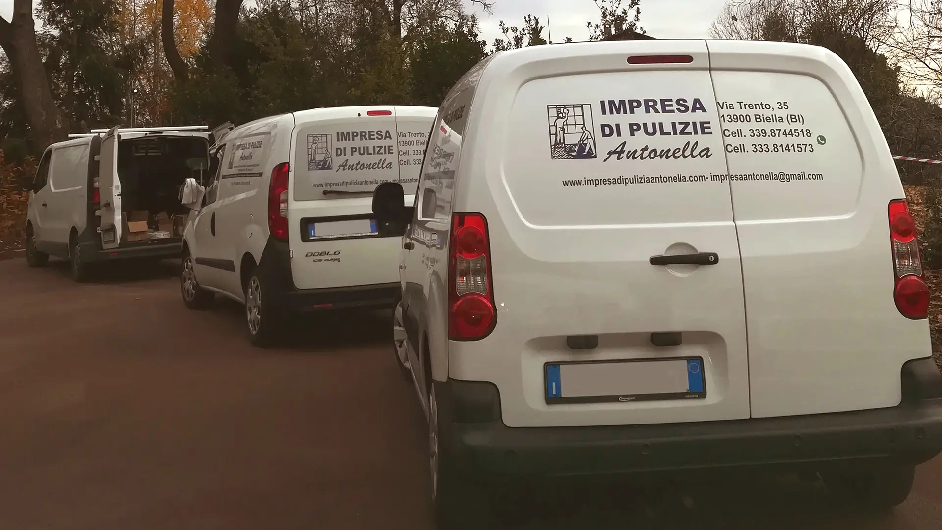 Impresa di pulizie Antonella Chi siamo. Serie di 3 Furgoncini biaanchi di Impresa di pulizie Antonella parcheggiati e incolonnati in fila indiana con decalcomanie 